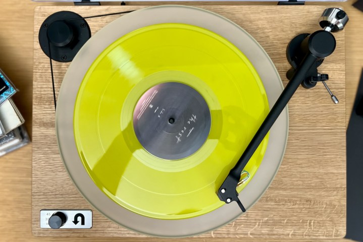A top-down image of the U-Turn Orbit Special turntable with a yellow record on it.