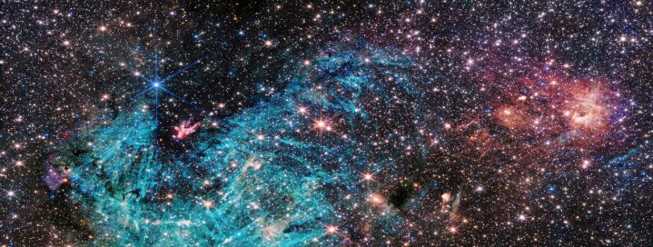La vista completa del instrumento NIRCam (Cámara de Infrarrojo Cercano) del Telescopio Espacial James Webb de la NASA/ESA/CSA revela una porción de 50 años luz de ancho del denso centro de la Vía Láctea. Se estima que 500.000 estrellas brillan en esta imagen de la región de Sagitario C (Sgr C), junto con algunas características aún no identificadas. Una vasta región de hidrógeno ionizado, que se muestra en cian, envuelve una nube oscura infrarroja, que es tan densa que bloquea la luz de estrellas distantes detrás de ella. Las intrigantes estructuras en forma de aguja en la emisión de hidrógeno ionizado carecen de una orientación uniforme. Los investigadores señalan la sorprendente extensión de la región ionizada, que abarca unos 25 años luz. Un cúmulo de protoestrellas, estrellas que aún se están formando y ganando masa, están produciendo flujos de salida que brillan como una hoguera en la base de la gran nube oscura infrarroja, lo que indica que están emergiendo del capullo protector de la nube y pronto se unirán a las filas de las estrellas más maduras a su alrededor. Nubes infrarrojas-oscuras más pequeñas salpican la escena, apareciendo como agujeros en el campo estelar. Los investigadores dicen que apenas han comenzado a profundizar en la gran cantidad de datos de alta resolución sin precedentes que Webb ha proporcionado sobre esta región, y muchas características merecen un estudio detallado. Esto incluye las nubes de color rosa en el lado derecho de la imagen, que nunca se han visto con tanto detalle.