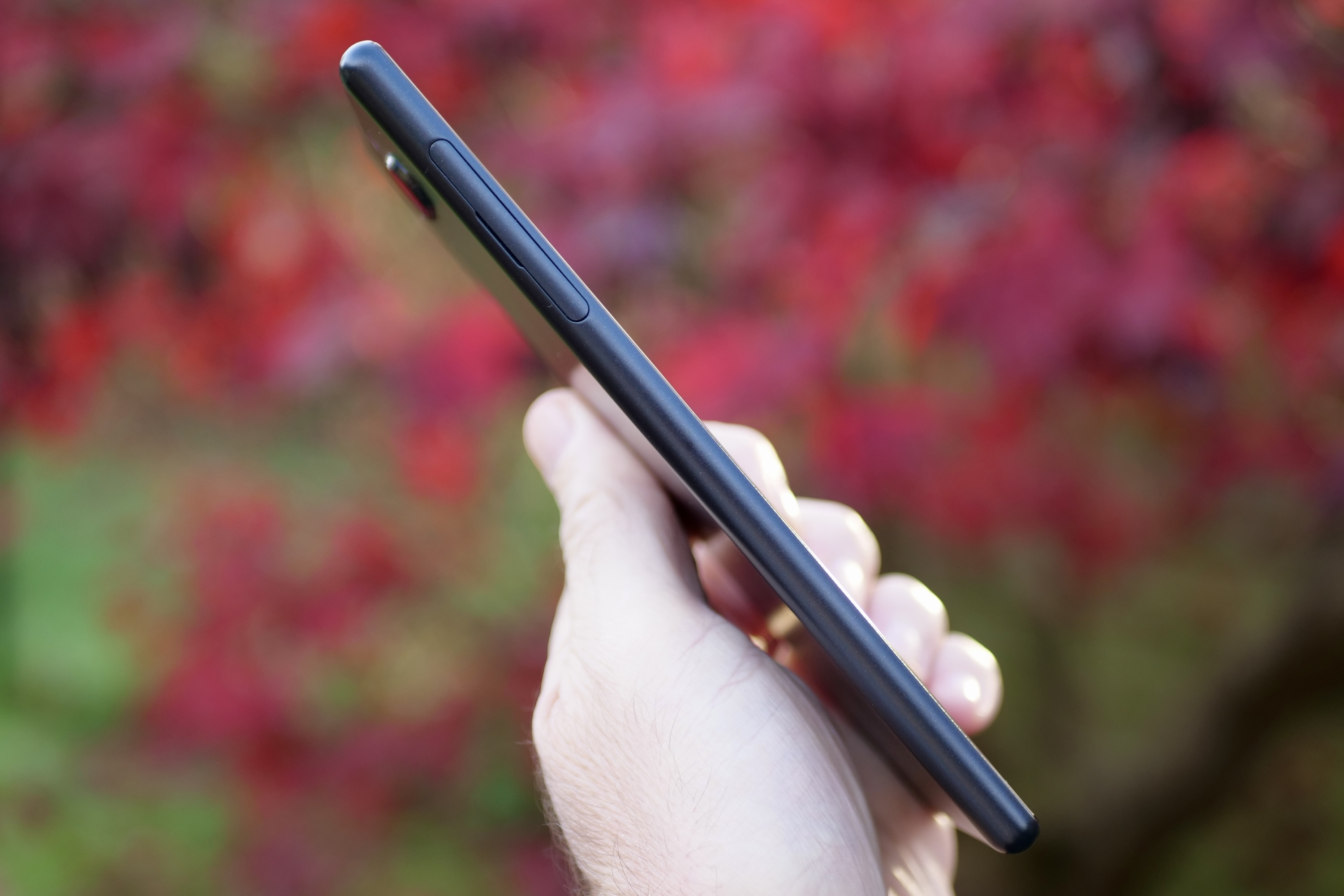 A person holding the Sony Xperia 10 Plus, showing the side of the phone.