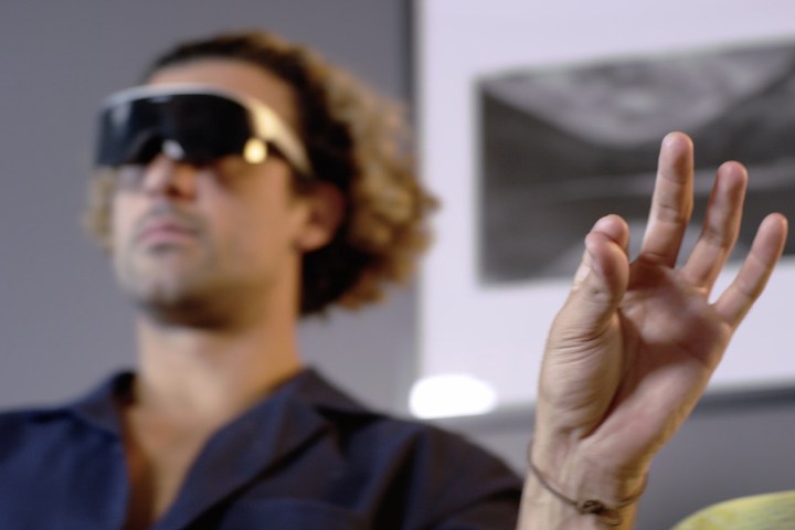 A person makes the pinch gesture while wearing the Immersed Visor headset.