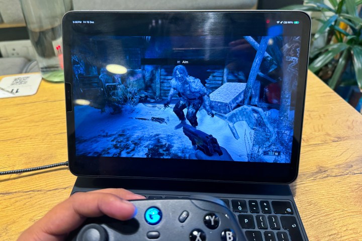 Использование контроллера для убийства монстра в Resident Evil Village на iPad Pro.