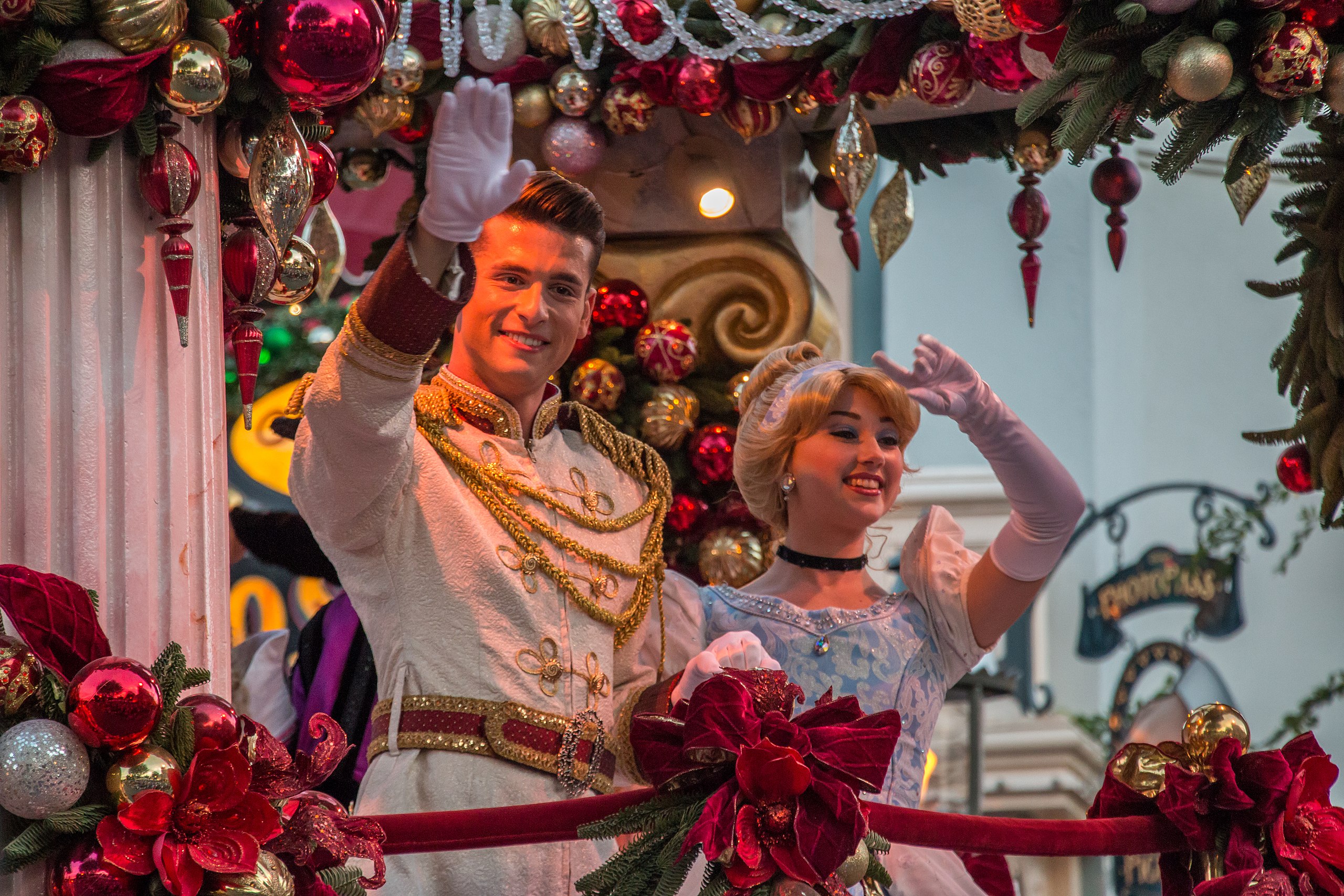 Prince Charming and Cinderella wave on top of a float.