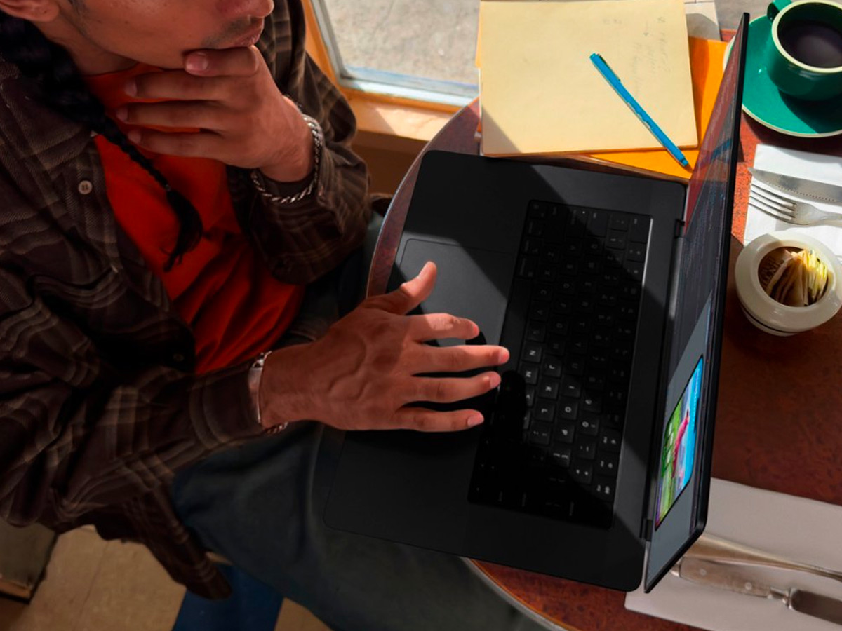 একটি টেবিলে Apple MacBook Pro 14-ইঞ্চি ব্যবহার করা।
