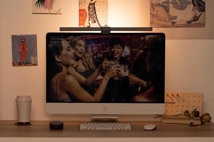 A BenQ ScreenBar Halo light on top of an iMac in a room.