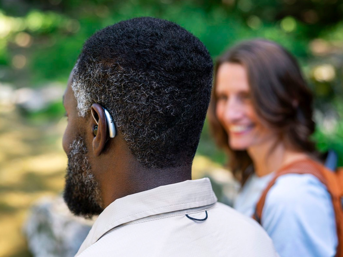 A man wears the Sennheiser All-Day Clear OTC hearing aid while on a hike.