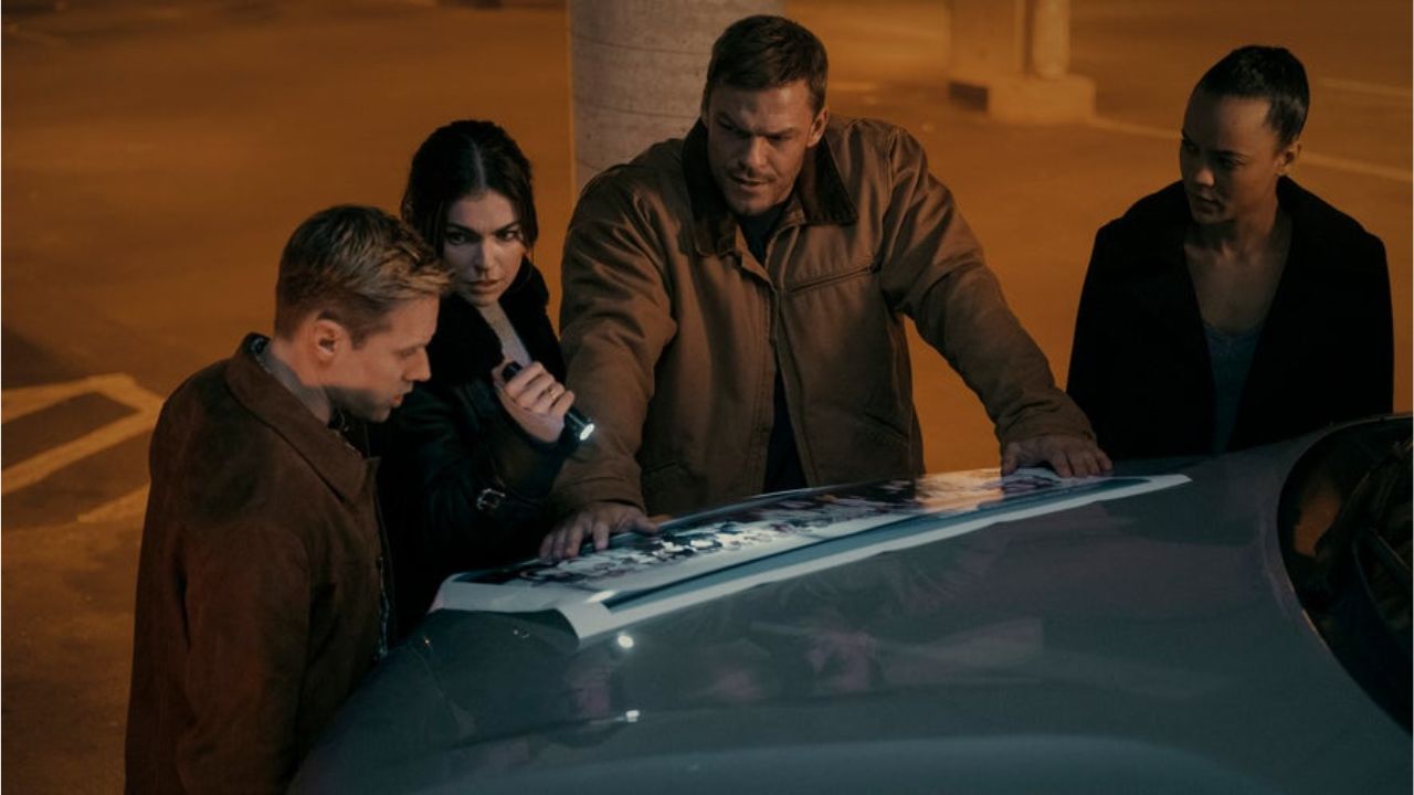 Shaun Sipos, Serinda Swan, Alan Ritchson, and Maria Sten as O'Donnell, Dixon, Reacher, and Neagley looking at a photo spread over a car hood in Reacher season 2.