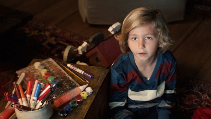 Zoomer looking up with arts and crafts around him in a scene from A Murder at the End of the World.