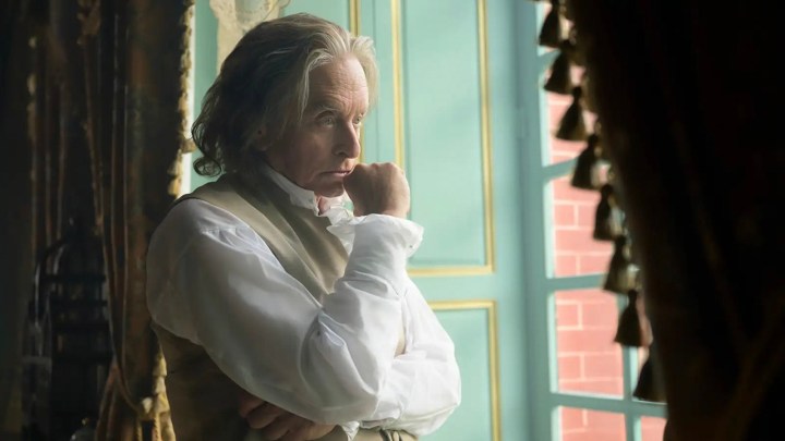 Michael Douglas as Benjamin Franklin stands by a window pondering, fist up to his chin in a scene from Franklin.