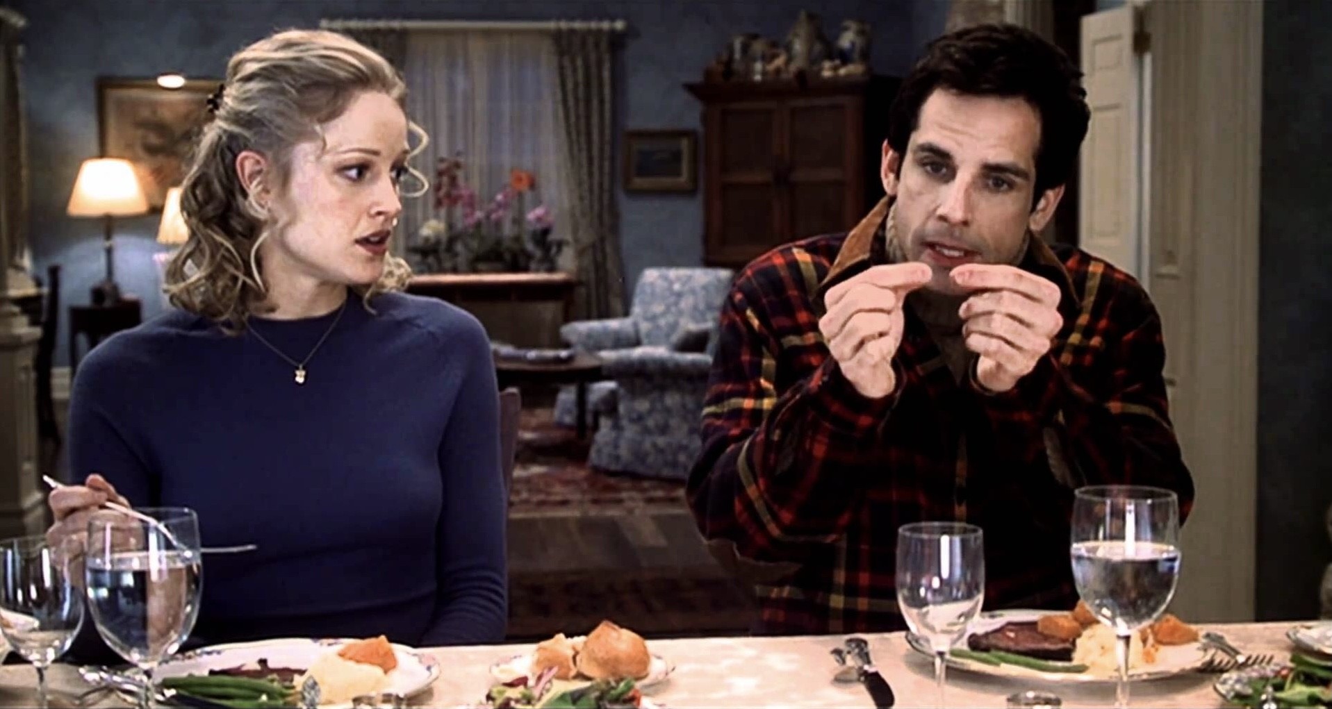 A man and a woman sit at a dinner table in Meet the Parents.
