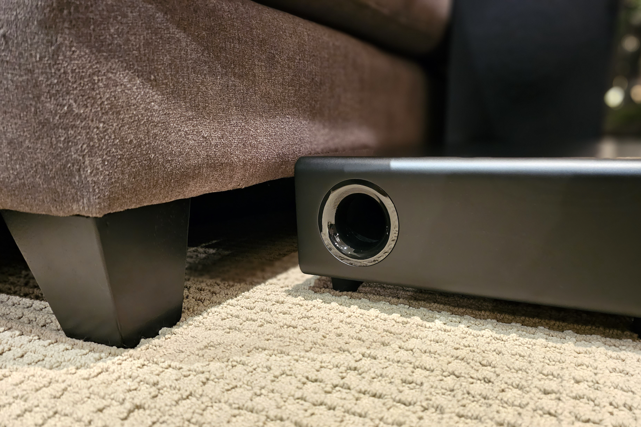 Platin Audio Milan 5.1.4 wireless subwoofer next to couch.