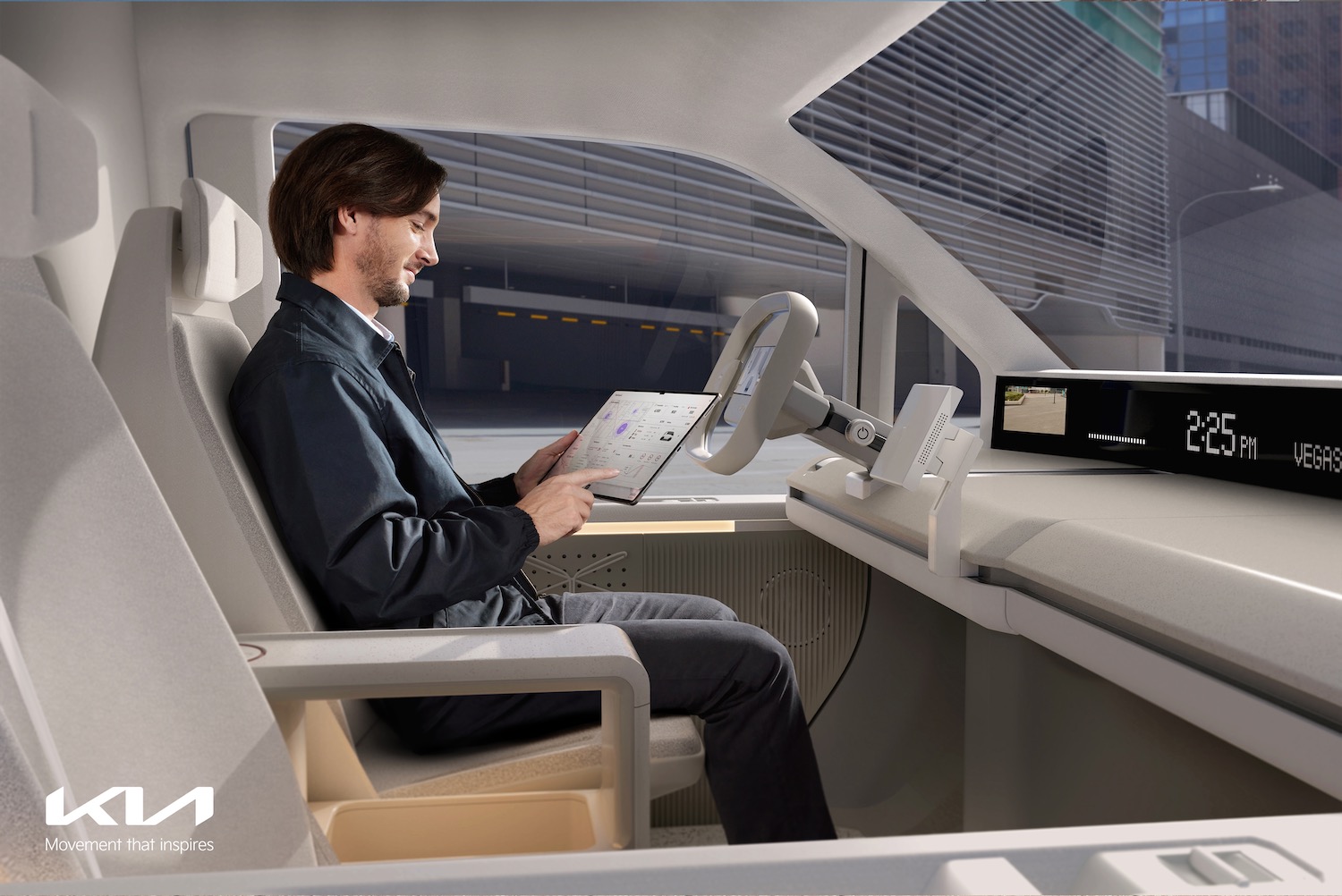 A person sitting in the driver's seat of a Kia Concept PV5 while looking at a tablet.