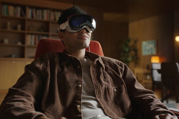 A person wears an Apple Vision Pro in a dim room.