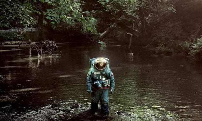 Adam Sandler walks through a jungle in Spaceman