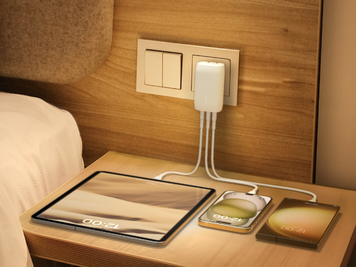Several devices plugged into the Belkin BoostCharge 3-port USB-C wall charger on a bedside table.