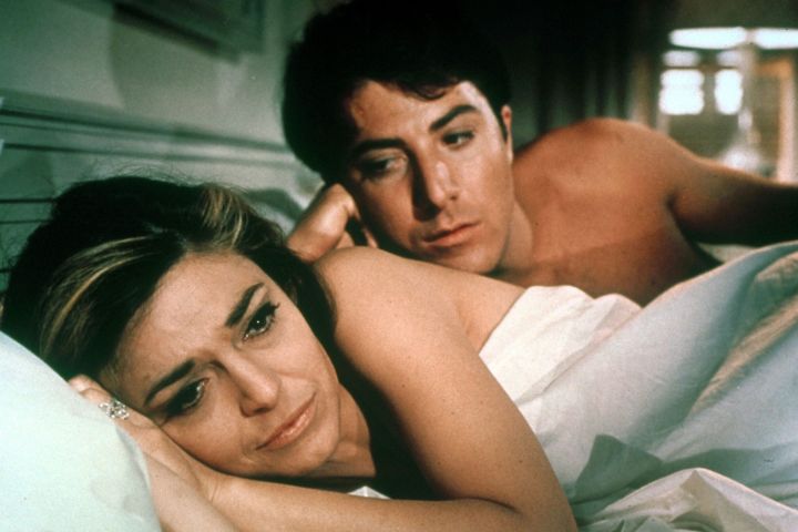 Dustin Hoffman mirando a Anne Bancroft mientras yacían en la cama en El graduado (1967).