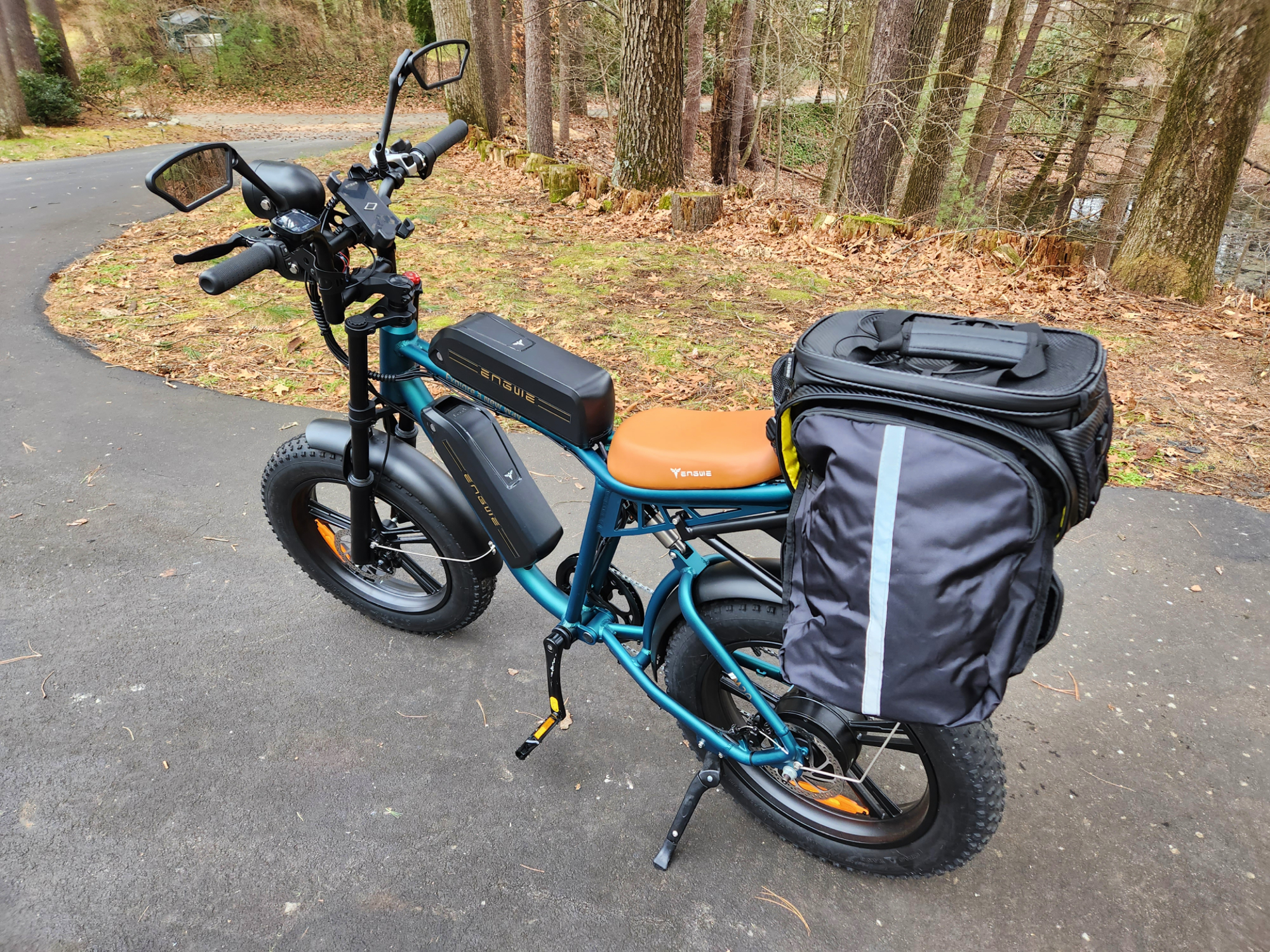 Engwe M20 e-bike with optional mirrors, phone mount, rear rack, and rack bag with panniers.