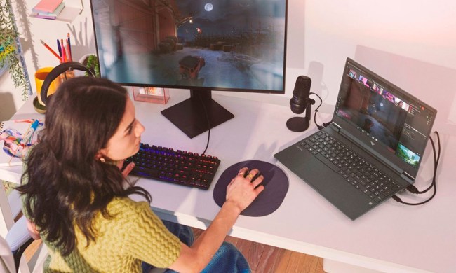 A girl plays games on the HP Victus 15.6-inch gaming laptop with a connected external display.