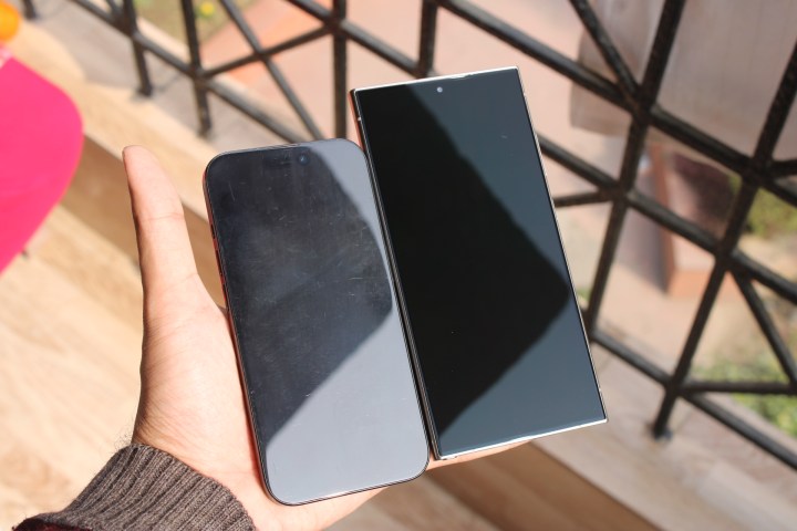 iPhone 15 Pro ve Galaxy S24 Ultra, S24 Ultra'nın yansıma önleme özelliğini daha iyi göstermek için ekran kapalıyken el altında.