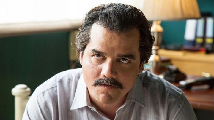 Wagner Moura como Pablo Escobar mirando atentamente a algún lugar fuera de cámara en Narcos de Netflix.