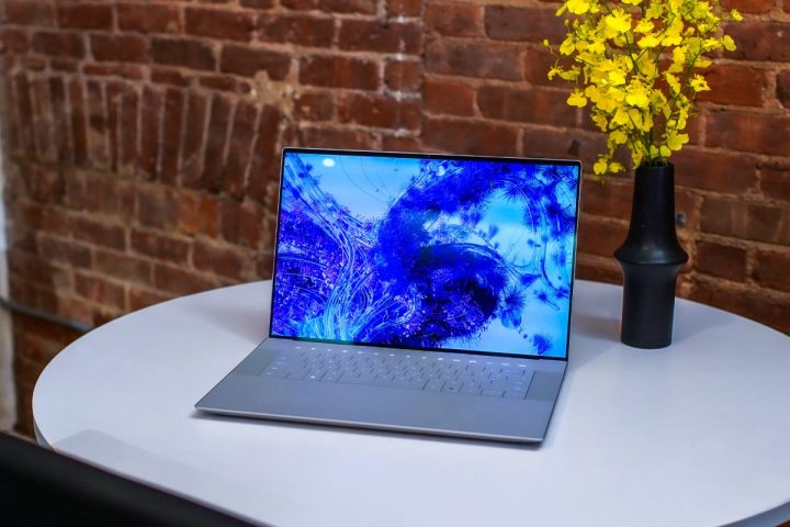 Dell XPS 16 sitting on desktop with flowers.