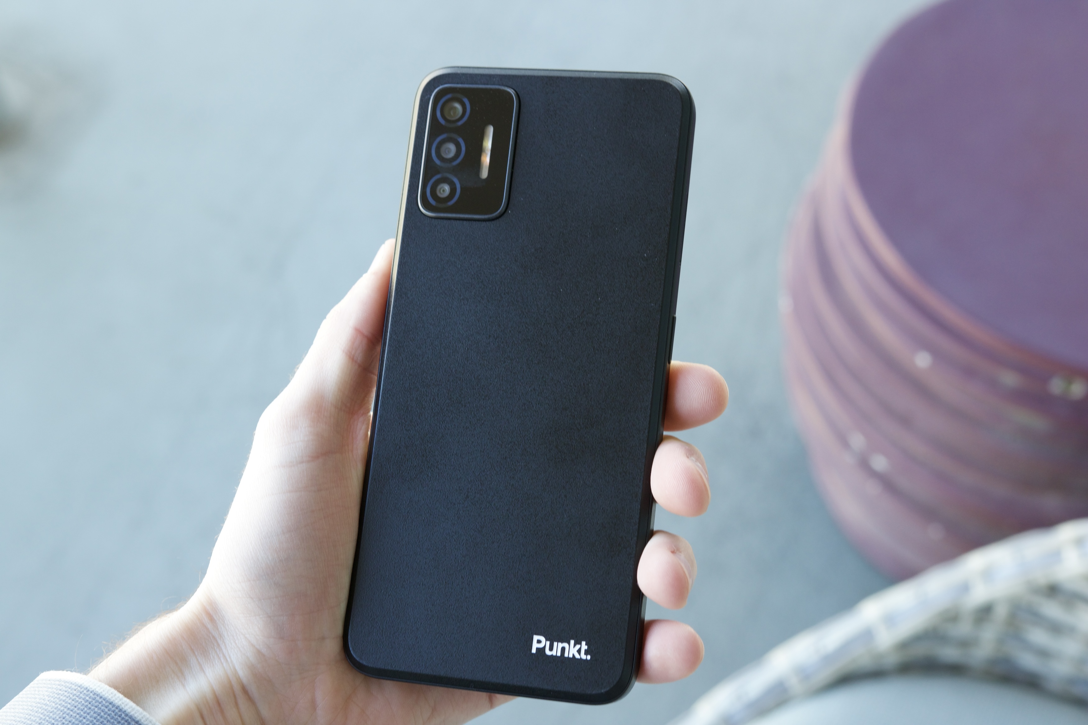 Someone holding the Punkt MCO2 smartphone and showing the back of it.