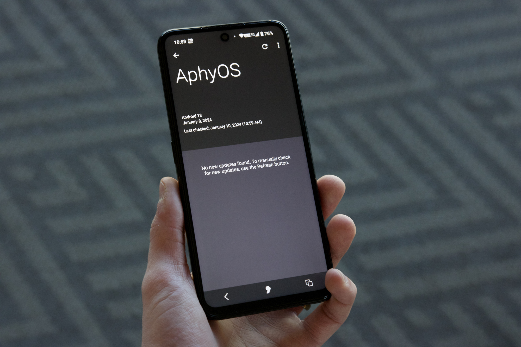 Someone holding a phone running Apostrophy OS, showing the AphyOS page.