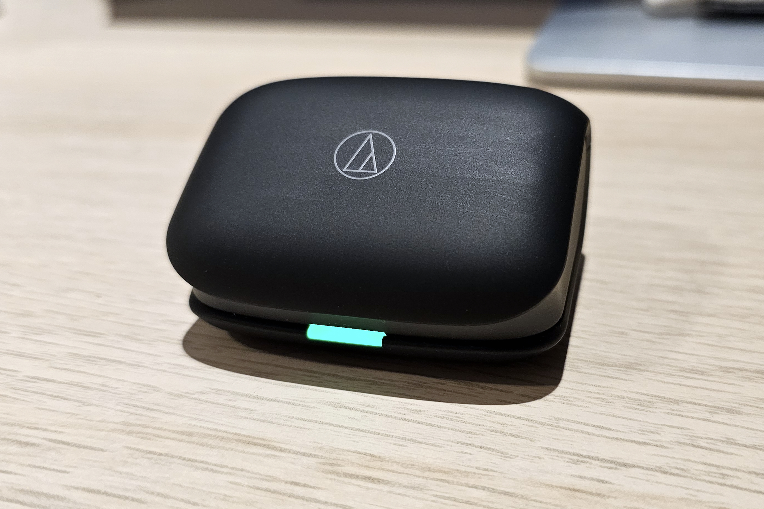 Audio-Technica ATH-TWX7 charging case closed with lit LED.