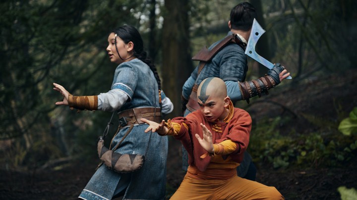 Tres personas, incluido un niño pequeño, se preparan para pelear en una escena de Avatar: The Last Airbender en Netflix.
