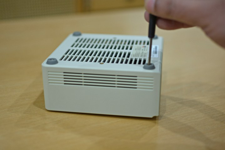 A screwdriver being used to open the bottom screws of the Ayaneo Retro Mini PC AM01.