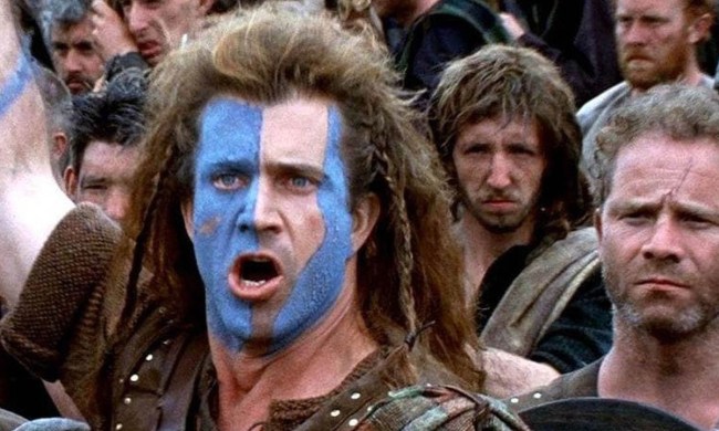 Mel Gibson as Braveheart with blue paint on his face leading people to battle.