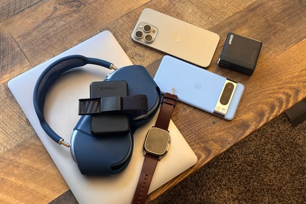 A MacBook, AirPods Max, Apple Peep, iPhone, Google Pixel, and Anker charger all lying subsequent to every varied on a desk.