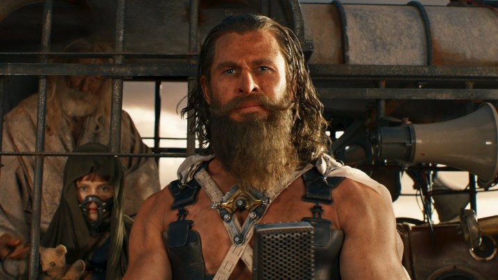 A bearded man looks ahead in Furiosa.