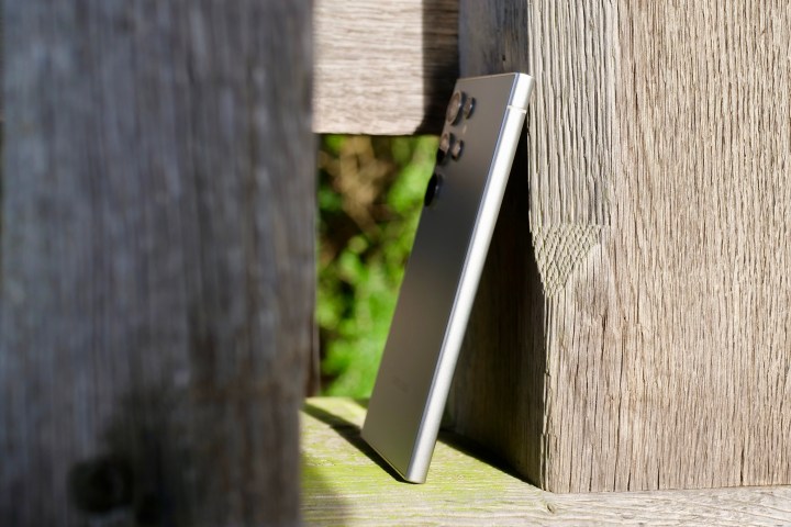 The Samsung Galaxy S24 Ultra from the side, resting against a post.