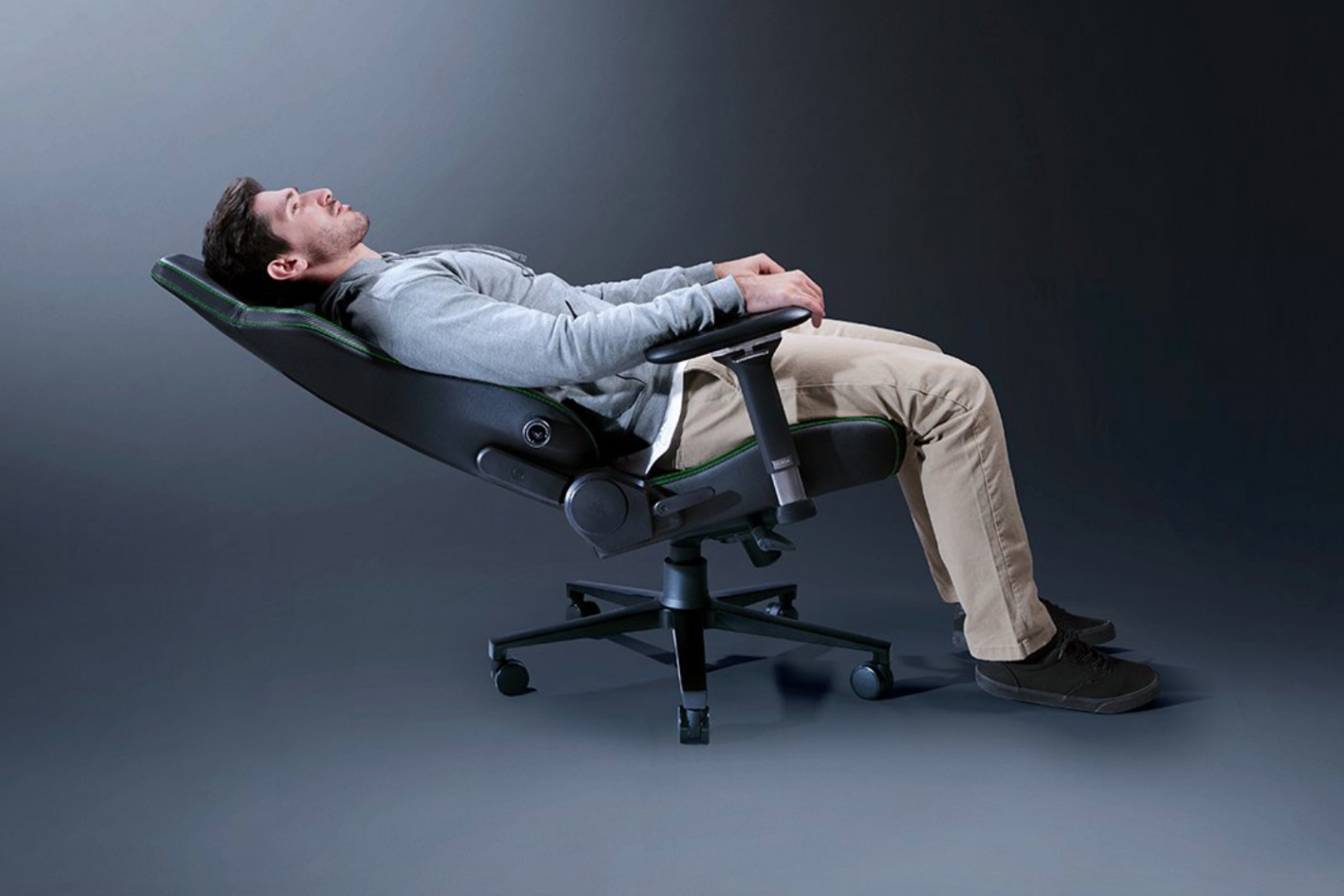 A model laying reclined on the Razer Izkur V2 gaming chair.