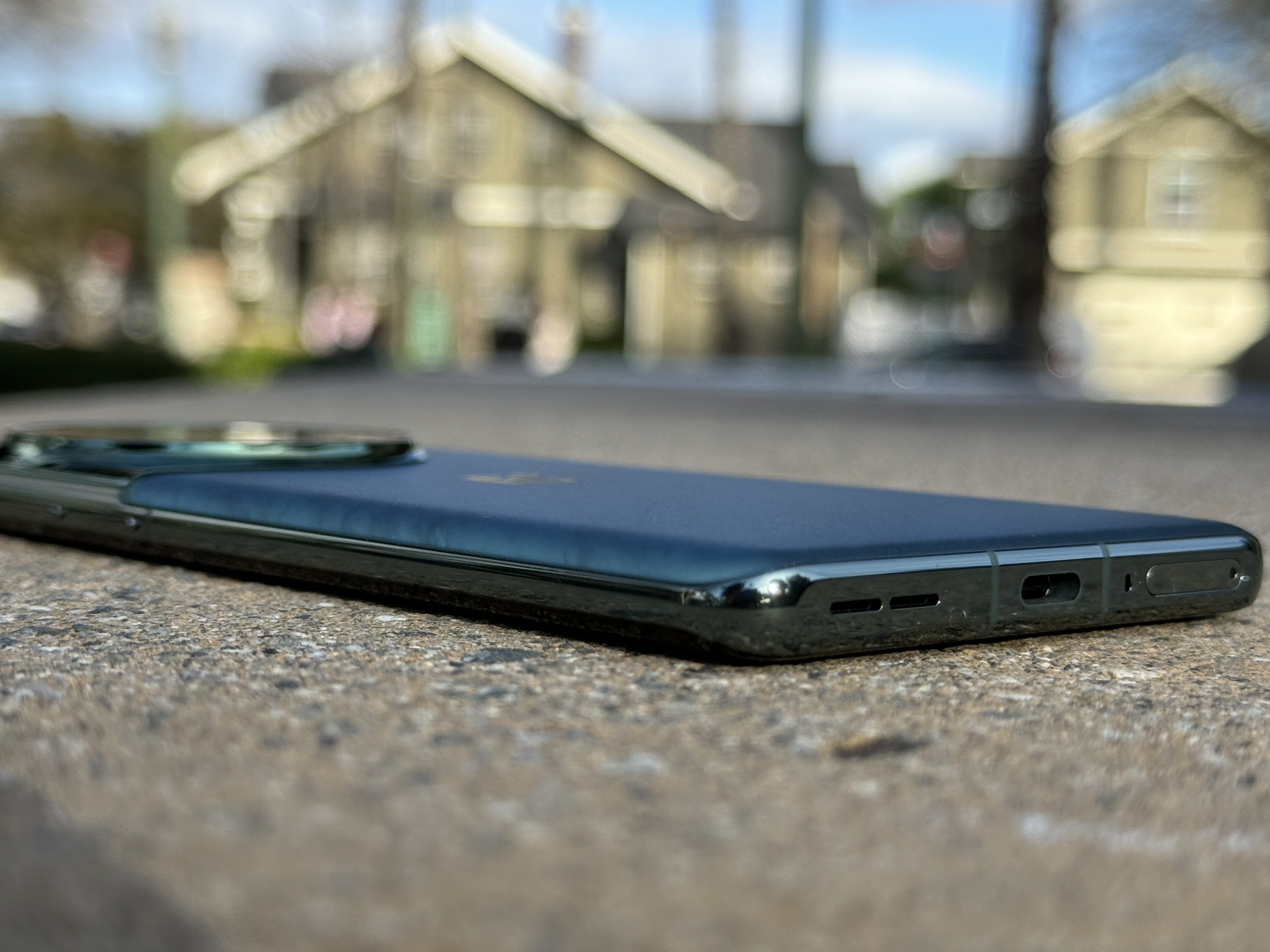OnePlus 12 Flowy Emerald angled to show flat edge bottom.
