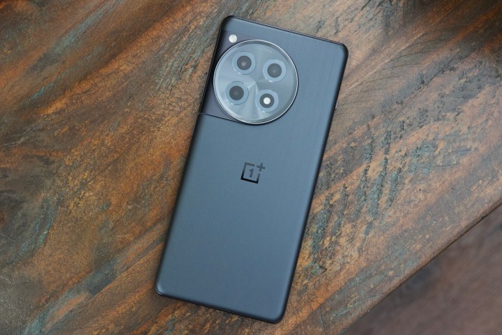 A black OnePlus 12R laying face down on a table.