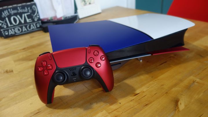 Une PS5 slim repose sur une table avec des plaques frontales de différentes couleurs.