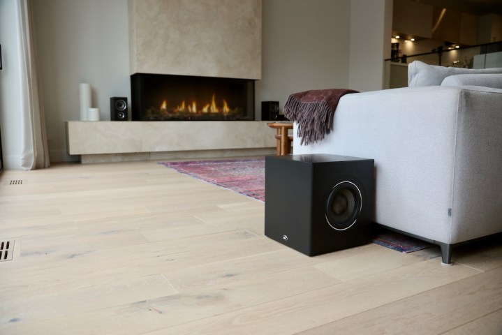 The PSB BP8 powered subwoofer agains the side of a couch from a wider angle.