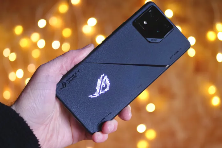 مردی که Asus ROG Phone 8 Pro را در دست دارد و پشت آن را نشان می دهد.