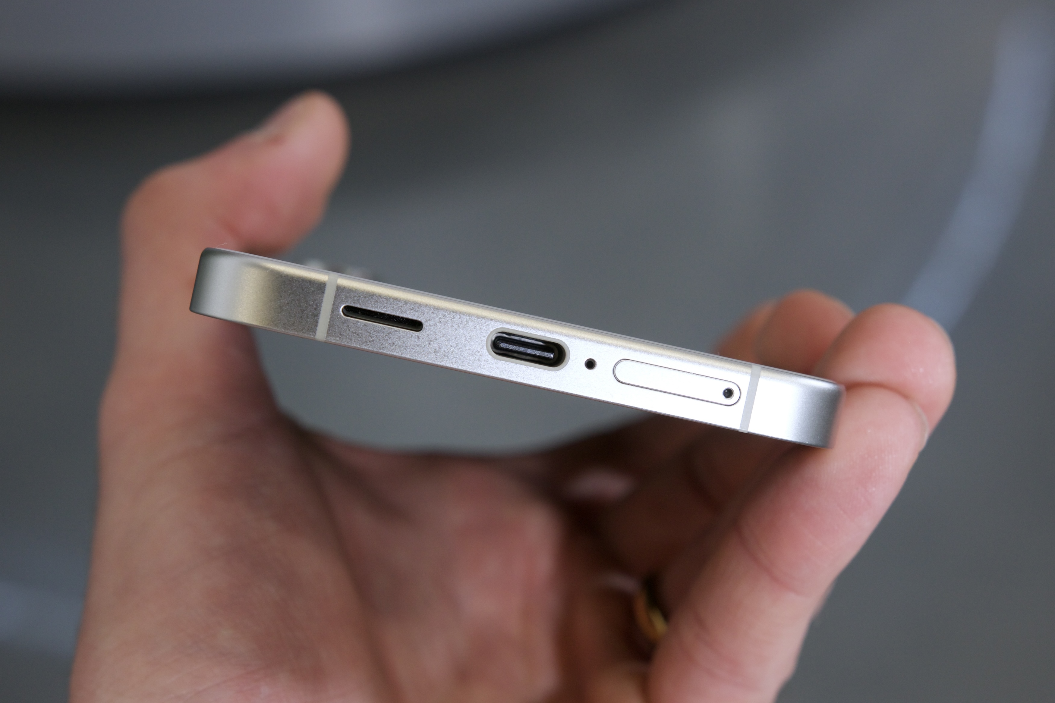 شخصی یک Samsung Galaxy S24 Plus را در دست گرفته و درگاه USB-C را نشان می دهد.
