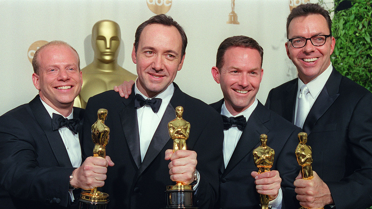 Four actors standing in a row posing with their Academy Awards at the 2000 ceremonies.