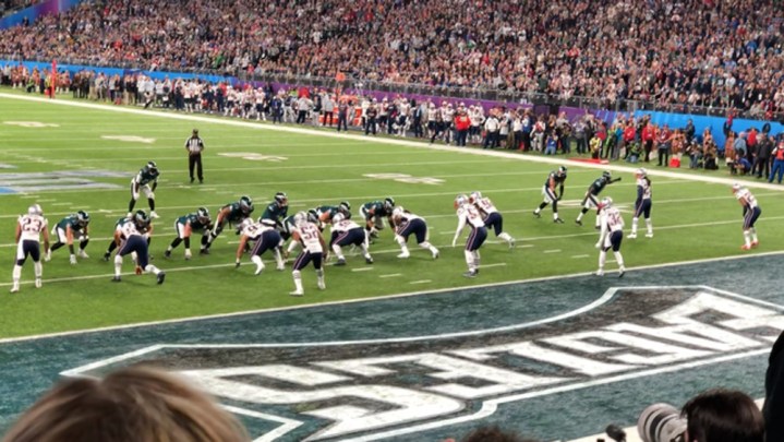 Players play on a football field at the Super Bowl LII.