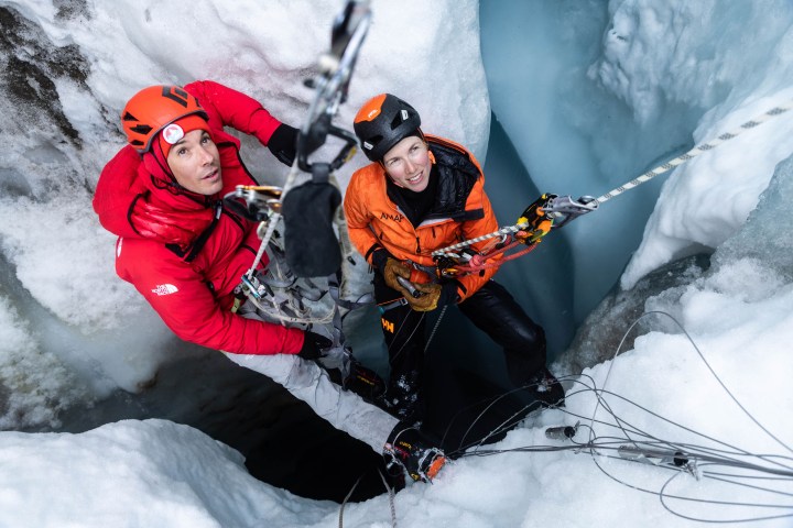 Два альпиниста пытаются подняться на ледник.