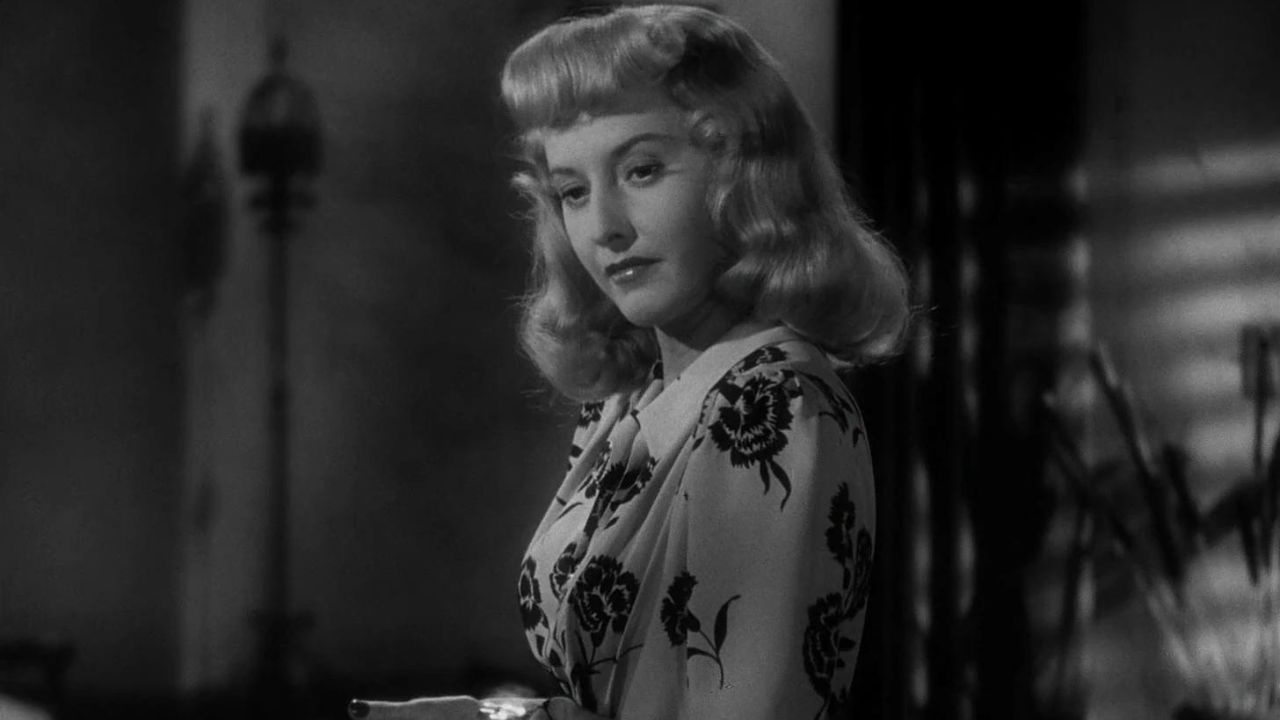 Barbara Stanwyck as Phyllis Dietrichson looking at something off-camera in the film Double Indemnity.