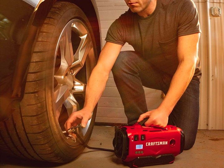 A man fills a tire with air with the Craftsman V20 portable tire inflator.