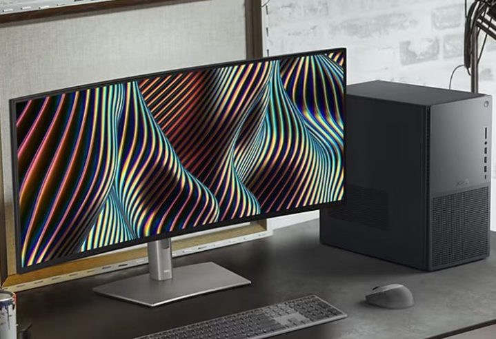 The Dell XPS Desktop on a desk placed next to a curved monitor.