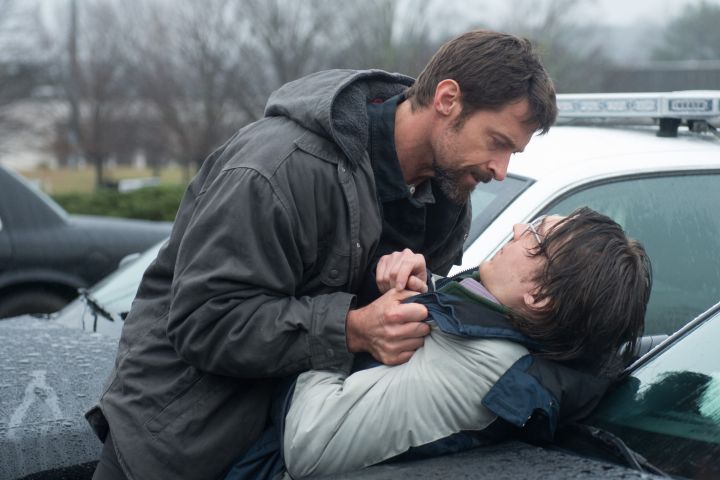 Hugh Jackman sosteniendo a Paul Dano por la chaqueta contra un coche en Prisoners (2013).
