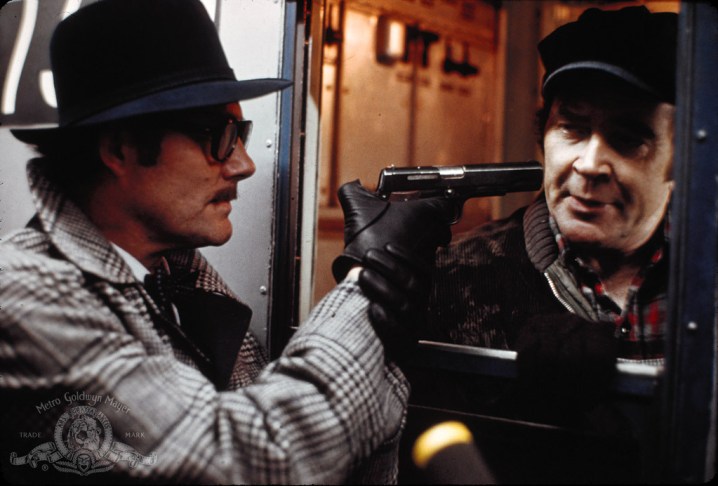 罗伯特·肖饰演的“蓝色先生”在《夺取佩勒姆 123》中威胁火车售票员。