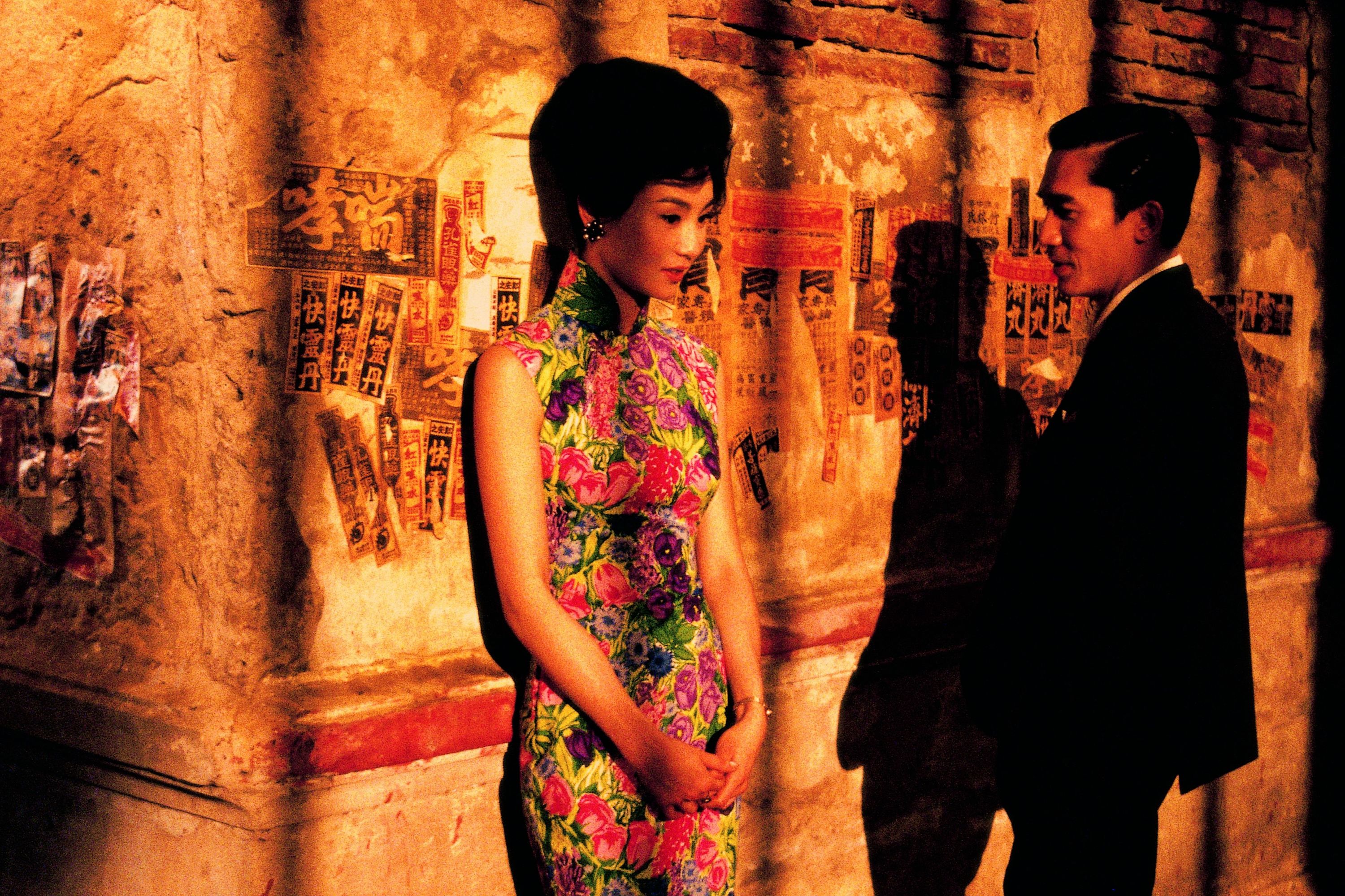In the Mood for Love (2000) filmindeki bir sahneden Maggie Cheung duvara yaslanmış ve Tony Leung Chiu-wai ona bakıyor