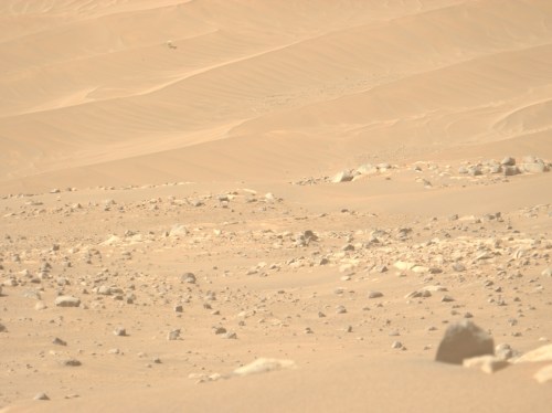A Mars landscape with NASA's Ingenuity helicopter in the background.